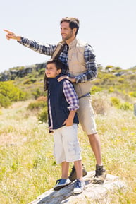 Father and son hiking in the mountains on a sunny day